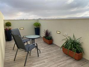 balcón con mesa, sillas y macetas en מעבר לאופק en Yeruham