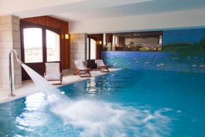 a swimming pool with a water slide in a building at Hotel Lou Granva in Grande Riviere