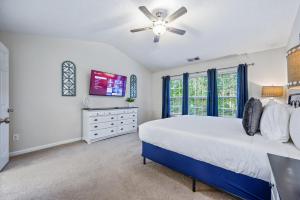 une chambre avec un lit et un ventilateur de plafond dans l'établissement Enjoy This Amazing Home With Porch & Grill Near DT, à Woodstock