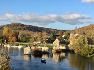a bridge over a river with a boat in the water at La petite duchesse Vernon Giverny in Vernon