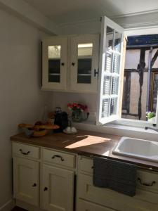 a kitchen with white cabinets and a sink and a window at La petite duchesse Vernon Giverny in Vernon