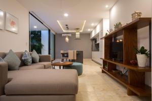 uma sala de estar com um sofá e uma televisão em Lovely 1 Bedroom Condo with plunge pool In Bahia Principe Golf Resort em Akumal