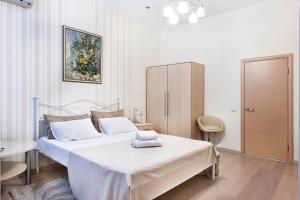 a white bedroom with a bed and a cabinet at Basseynaya Apart Hotel in Kyiv