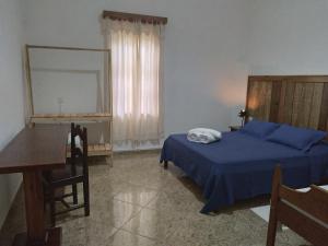 een slaapkamer met een bed, een bureau en een spiegel bij casa de mineiro in Tiradentes