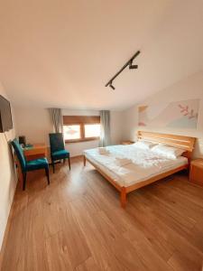 a bedroom with a large bed and two chairs at Mint Hotel in Prizren