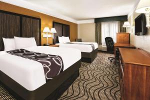 a hotel room with two beds and a desk at La Quinta by Wyndham San Antonio North Stone Oak in San Antonio