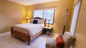 a bedroom with a bed and a chair and a window at Royal Poinciana Stay in Miami