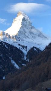 einen schneebedeckten Berg auf einem Hügel in der Unterkunft Appartamento con vista unica Condominio Grand'Ourse in Breuil-Cervinia