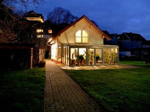 a house with large windows on a lawn at night at Ferienhaus Crowson in Cabarz