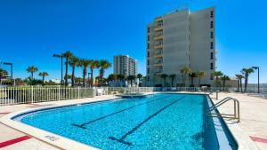 a swimming pool in front of a building with palm trees at Sans Souci unit 706 in Pensacola Beach