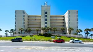 a large building with cars parked in front of it at Sans Souci unit 706 in Pensacola Beach