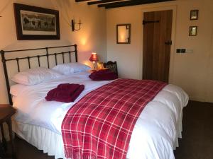 a bedroom with a large bed with red towels on it at The Stables in Ashover