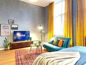 a living room with a blue couch and a tv at Klassen Stay - Exklusives Altbau Apartment - Zentral - Rheinnähe in Koblenz