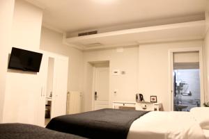 sypialnia z łóżkiem i telewizorem na ścianie w obiekcie Hotel 900 Toscana we Florencji