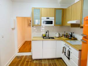una cocina con armarios blancos y fregadero en Spacious 1 bedroom apartment with a Parking Spot in Chiado, en Lisboa