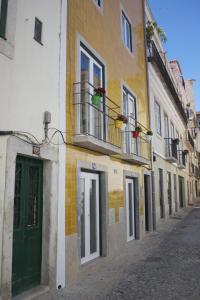 リスボンにあるドゥケズ アパートメンツの緑の扉が並ぶ建物