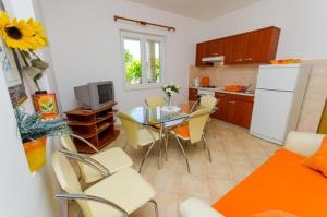 uma cozinha com uma mesa e cadeiras e um frigorífico branco em Apartments Iva - 150m from the beach em Trogir