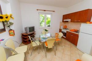 uma cozinha com uma mesa e cadeiras e um frigorífico em Apartments Iva - 150m from the beach em Trogir