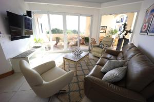 a living room with a leather couch and chairs at Brandnew Luxury 2Bdr condo✰Stunning view✰Fast wifi in Tamarindo