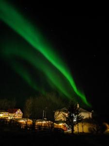 een afbeelding van het noorderlicht in de lucht bij The Castle in Búðardalur