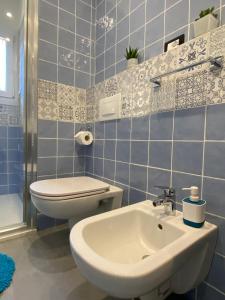 ボローニャにあるMazzini Malpighi Apartmentの青いタイル張りのバスルーム(トイレ、シンク付) +34枚の写真