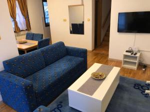 un soggiorno con divano blu e tavolo di Linden Tree Apartment a Fojnica