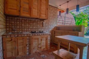 a kitchen with wooden cabinets and a wooden table at Kubu Kayana Batuan in Sukawati