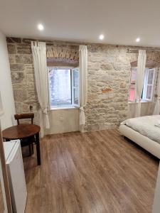 1 dormitorio con cama, mesa y ventana en Sebenico Luxury Rooms, en Šibenik