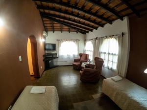 1 dormitorio con 2 camas y sala de estar en Posada del Virrey en Merlo