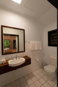 a bathroom with a toilet, sink and mirror at Cape Trib Beach House in Cape Tribulation