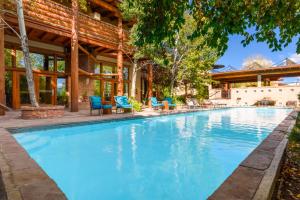 a swimming pool with blue chairs and a house at Chipeta Lodge in Ridgway