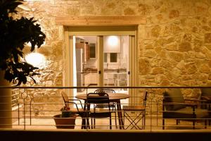 a balcony with a table and chairs and a stone wall at Gallery Suites Parga in Parga