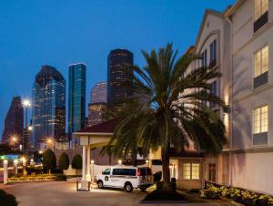 een wit busje geparkeerd voor een gebouw met een palmboom bij Best Western Plus Downtown Inn & Suites in Houston