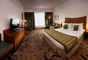 ノイダにあるRadisson Blu MBD Hotel Noidaのベッドとテレビが備わるホテルルームです。