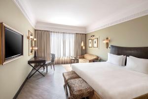 a hotel room with a large bed and a desk at Radisson Blu MBD Hotel Noida in Noida