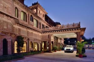 ein Auto, das unter einer Brücke vor einem Gebäude geparkt ist in der Unterkunft Radisson Jodhpur in Jodhpur