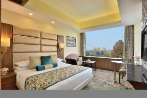 Habitación de hotel con cama y ventana grande en Radisson Srinagar en Srinagar