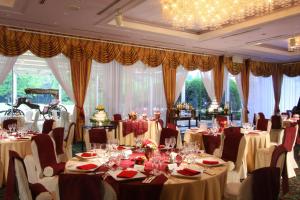 uma sala de banquetes com mesas e cadeiras com mesa em International Resort Hotel Yurakujo em Narita