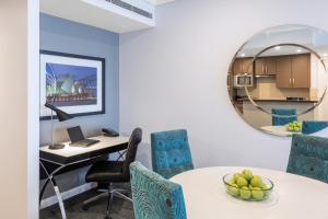 a room with a table and chairs and a mirror at Meriton Suites World Tower, Sydney in Sydney