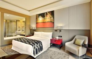 a bedroom with a large bed and a chair at Radisson Blu Faridabad in Faridabad