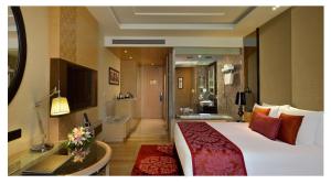 a hotel room with a large bed and a bathroom at Radisson Blu Jaipur in Jaipur