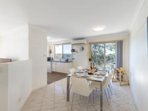 a kitchen and dining room with a table and chairs at Sea Breeze, 1,23 Stubby St Nelson Bay - Pet Friendly duplex with boat parking, air con and wi-fi in Nelson Bay