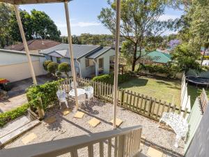 a house with a fence and chairs in a yard at Sea Breeze, 1,23 Stubby St Nelson Bay - Pet Friendly duplex with boat parking, air con and wi-fi in Nelson Bay