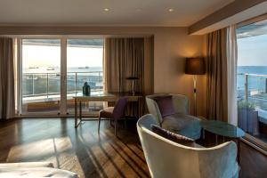 sala de estar con mesa y sillas y balcón en Radisson Blu Hotel Istanbul Ottomare, en Estambul