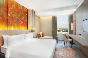 a hotel room with a bed and a large window at Radisson Lampung Kedaton in Bandar Lampung +37 photos
