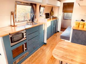 a kitchen with blue cabinets and a sink and a table at Vintage 1962 airstream in Oxford