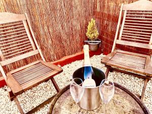 a bottle of wine sitting on a table with two chairs at Vintage 1962 airstream in Oxford