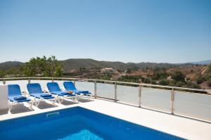 balcón con sillas y piscina en Casa da Ribeira, en Silves