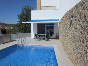 ein Haus mit einem Pool neben einer Steinmauer in der Unterkunft Casa da Ribeira in Silves