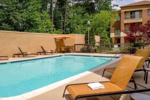 una piscina con sillas y un hotel en Sonesta Select Durham Research Triangle Park en Durham